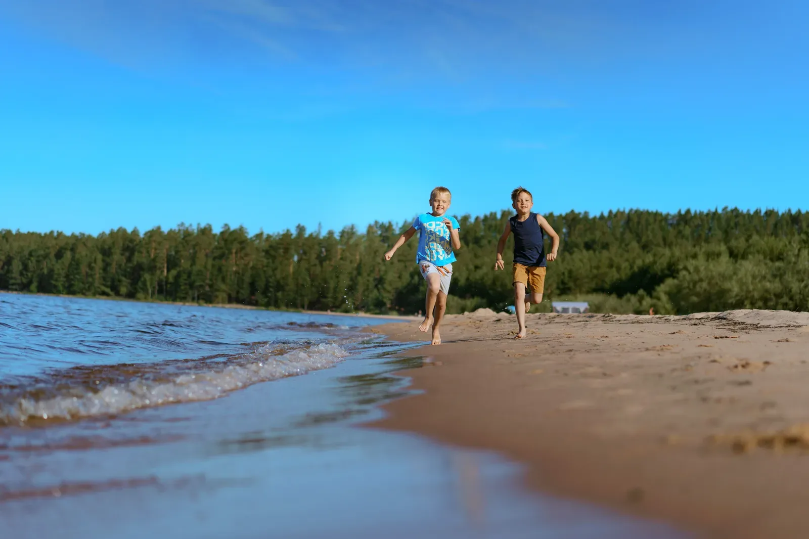 Happy kids running together along the seaside