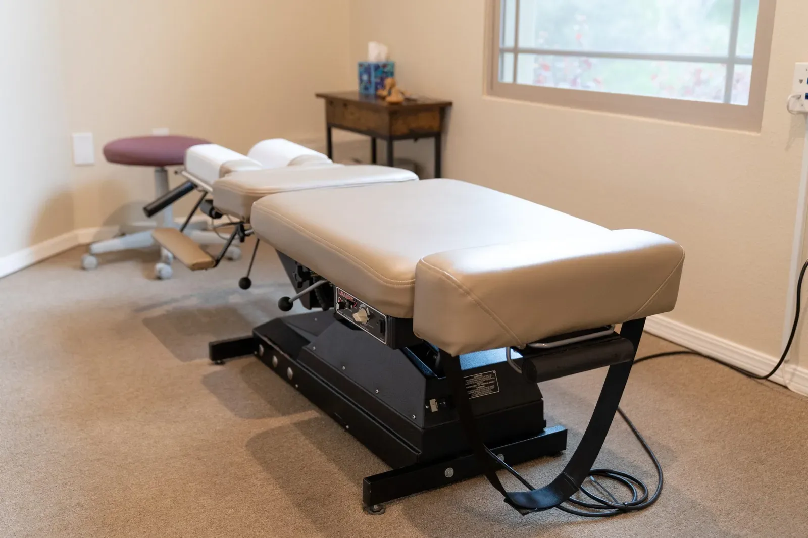 Chiropractic treatment room with adjustment table and equipment
